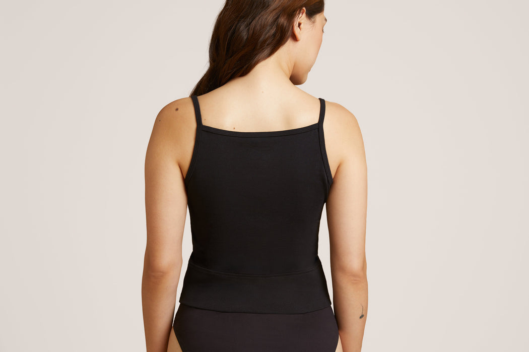 Back angle of a model wearing Slick Chicks Adaptive Two-Way Front Zip Cami in black, against a plain white background