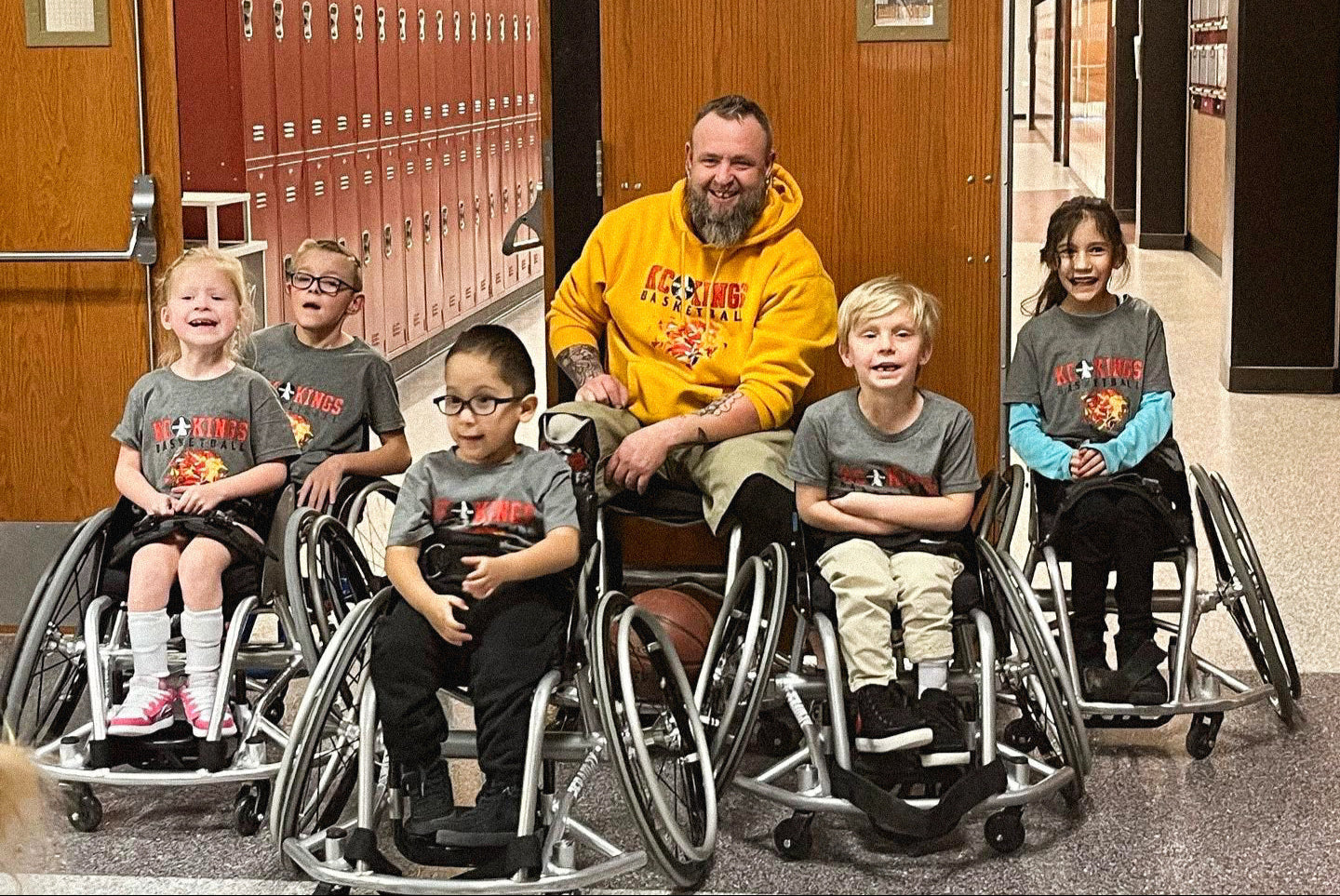 Group portrait of the team of 5 Kansas City Kings Youth Wheelchair Basketball team with Jason Loftiss