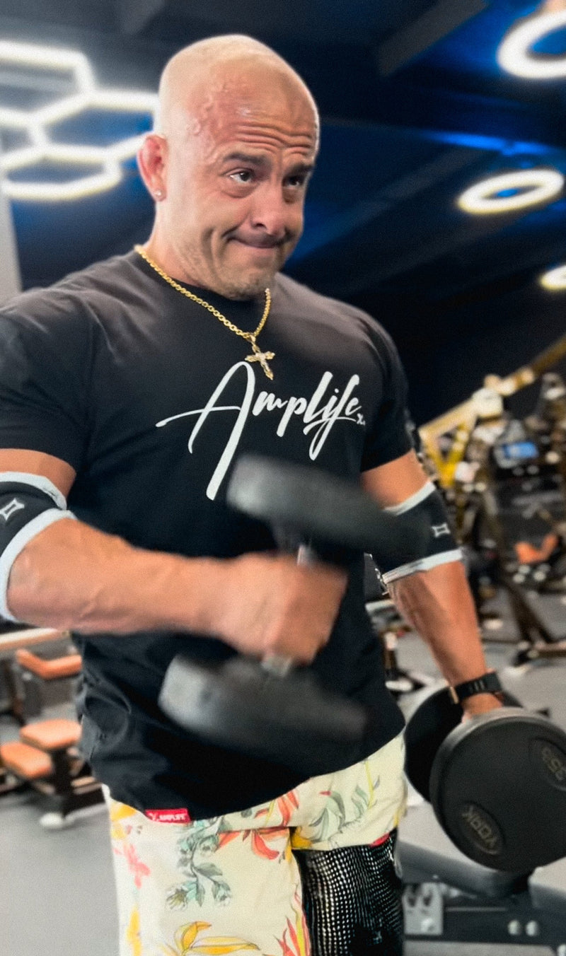 Team Amplife® Ambassador Tomás De La Mora wearing the Amplife® Signature T-Shirt in the gym while performing hammer curls