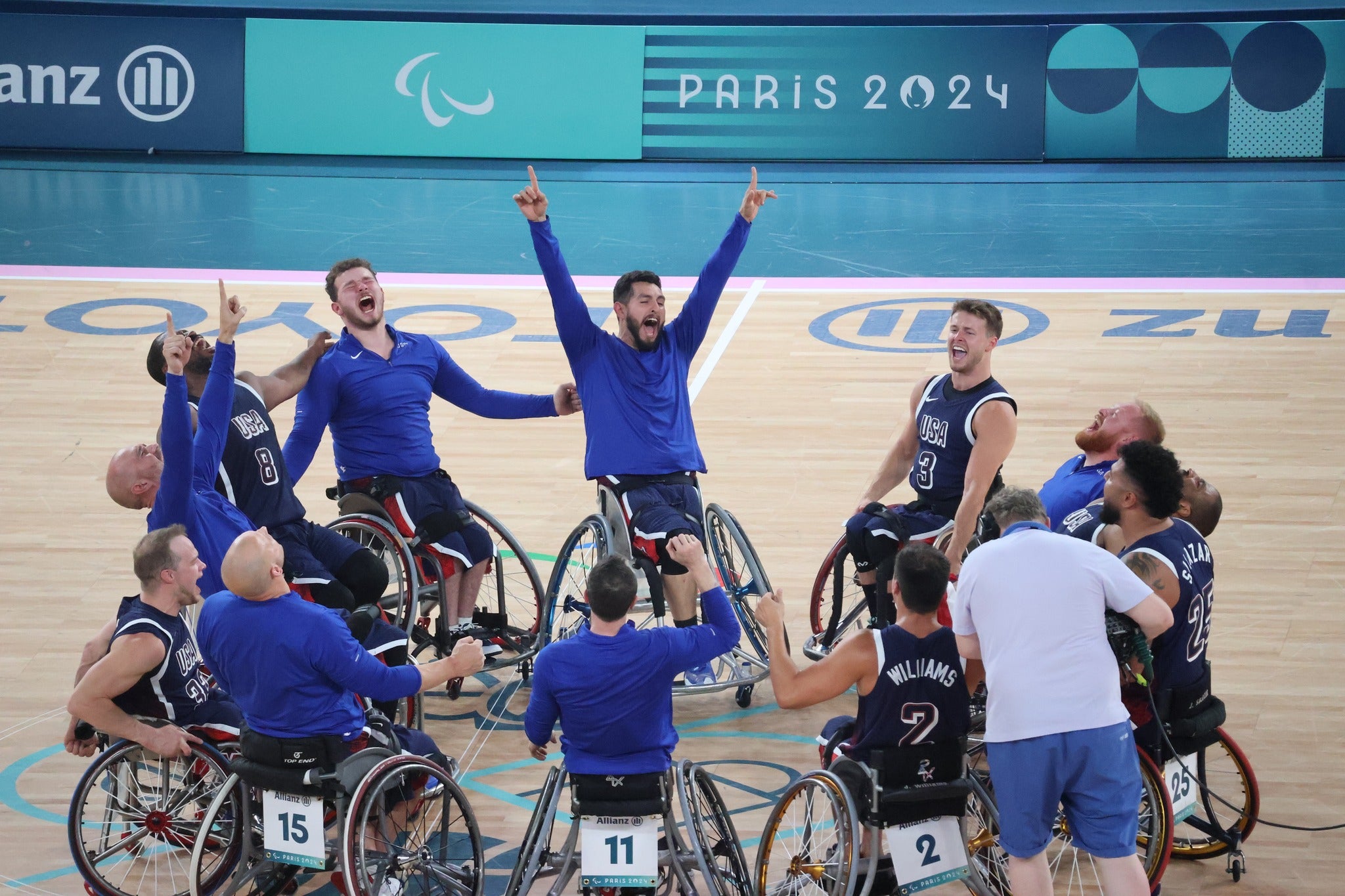 Team USA Wheelchair basketball players celebrating on a court after winning gold in the 2024 Paris Paralympics