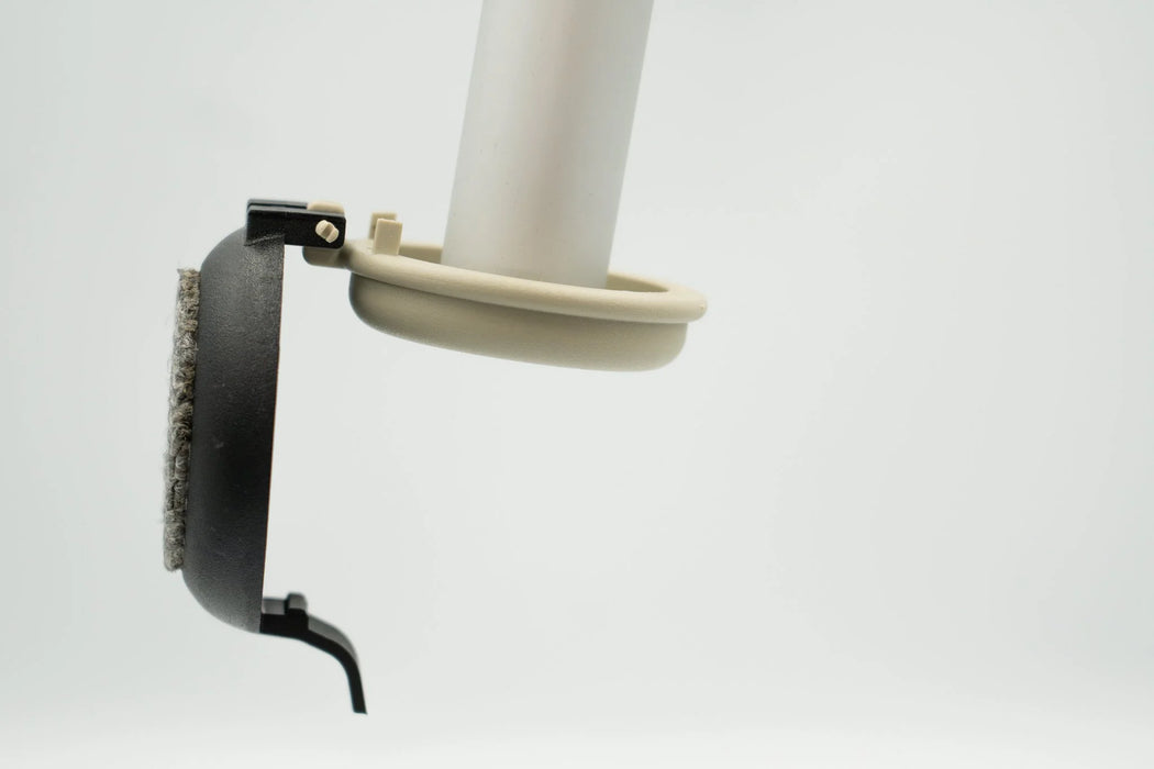 Side angle of the Versa Select black coaster hanging from its hinge pin on the tan base puck of a walker leg