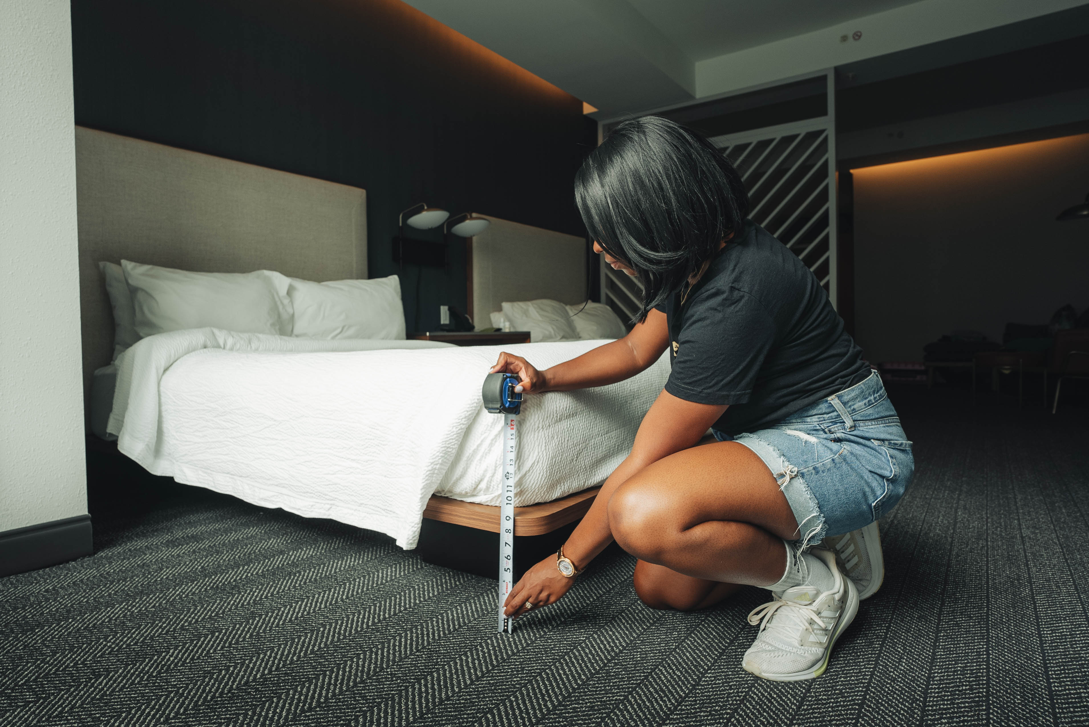 Person measuring height of a bed to verify accessibility details for Wheel the World