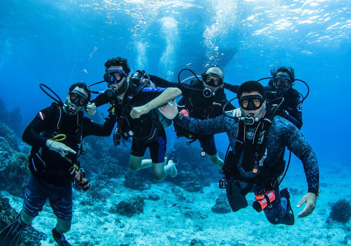 Group of scuba divers underwater in a blue ocean