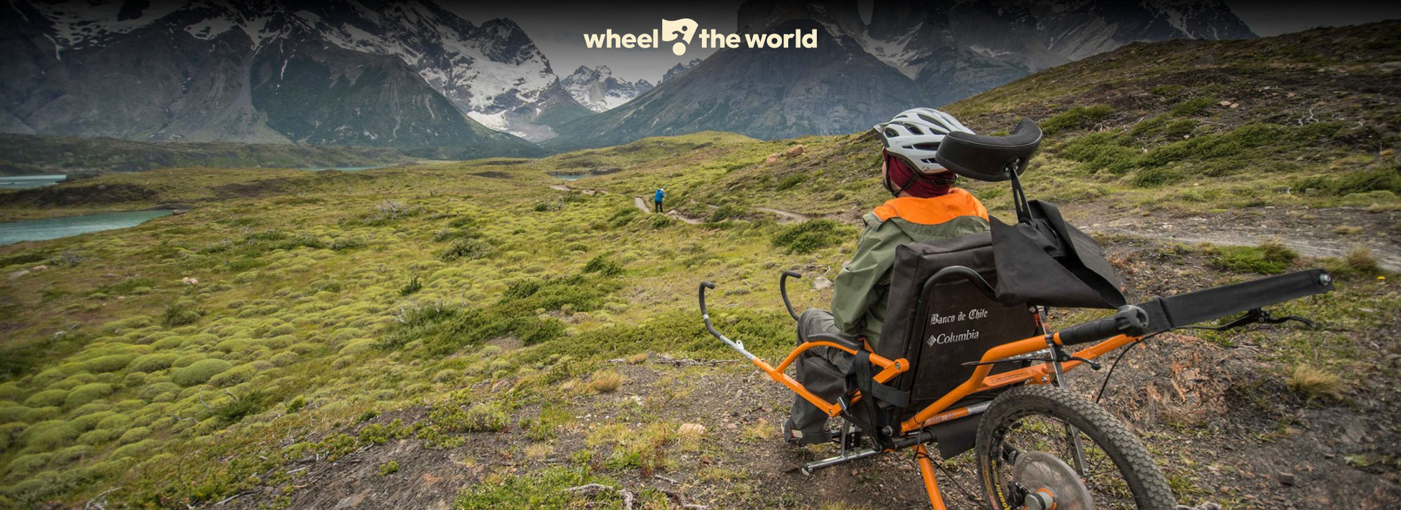 Person with an accessible mountain bike and backpack in a mountainous landscape.