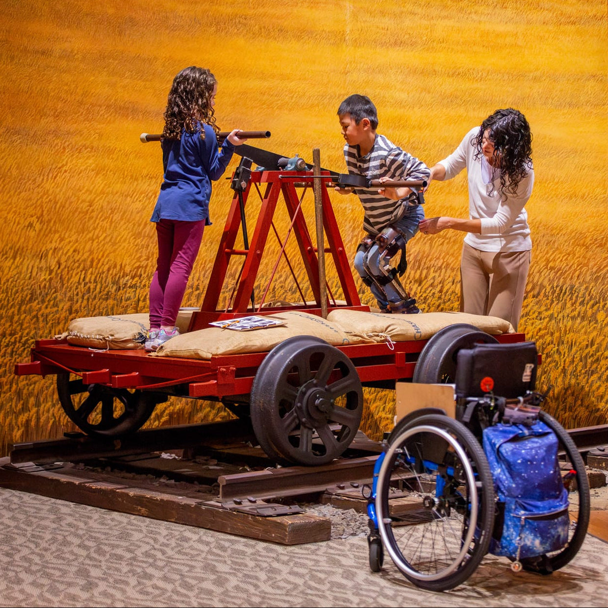 Children playing with a toy cart in a museum setting