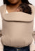 Detail of woman holding a baby in a WildBird Desert Lark Aerial Buckle Baby Carrier on a white background