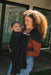 Woman holding a baby in a WildBird Raven Linen Baby Sling outdoors