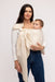 Woman holding a baby in a WildBird Sparrow Linen Baby Sling on a white background