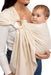 Front side detail of woman holding a baby in a WildBird Sparrow Linen Baby Sling on a white background
