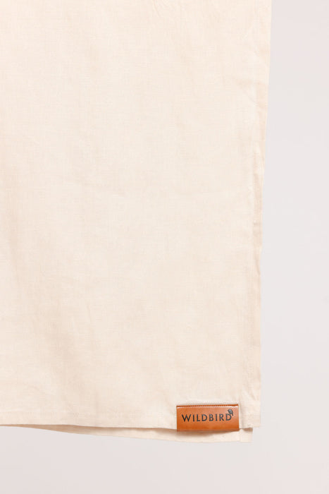 Detail of WildBird Sparrow Linen Baby Sling brown leather label on a white background