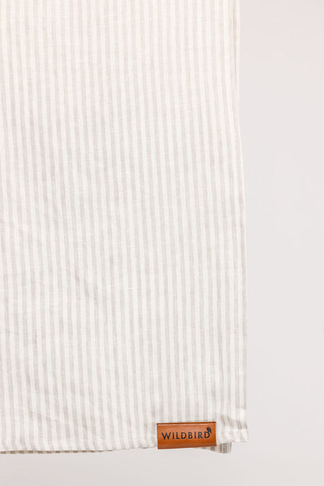 Detail of WildBird Swan Linen Baby Sling brown leather label on a white background