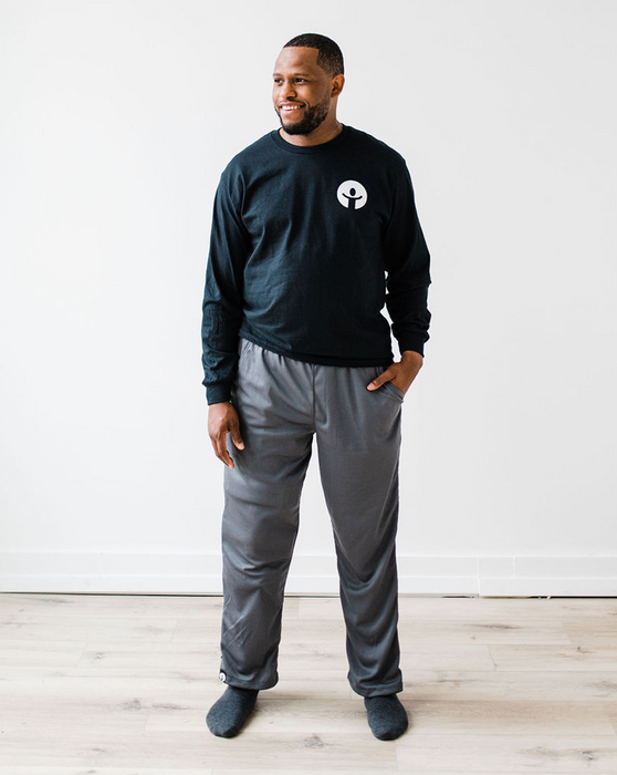 Man wearing the befree zipOns Adult Heavyweight Adaptive Pants standing against a white wall.
