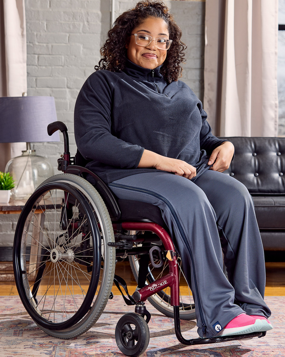 Woman in a wheelchair wearing the befree zipOns Adult Lightweight Adaptive Pants in a living room setting