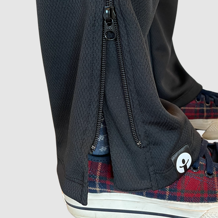 Detail of bottom unzipped on the befree zipOns Youth Heavyweight Adaptive Pants worn on model on a white background