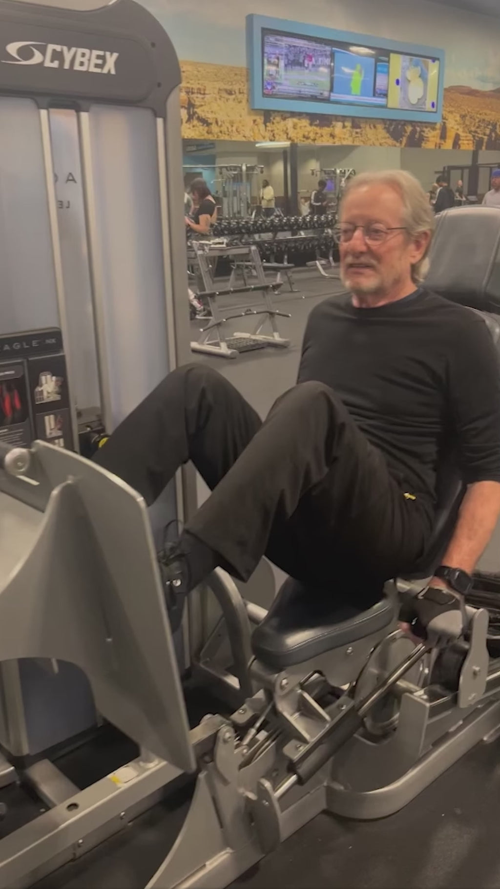 SuZanne Jacobsen helping a client on the leg press machine in the gym.