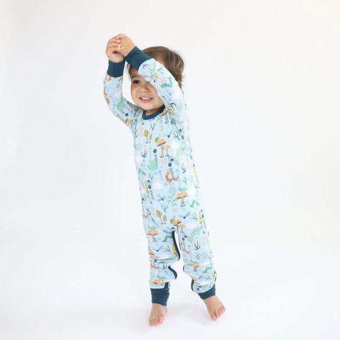 Child standing while wearing a Rainn Bamboo Critter Hollow Crescent Zipp Jammies on a white background