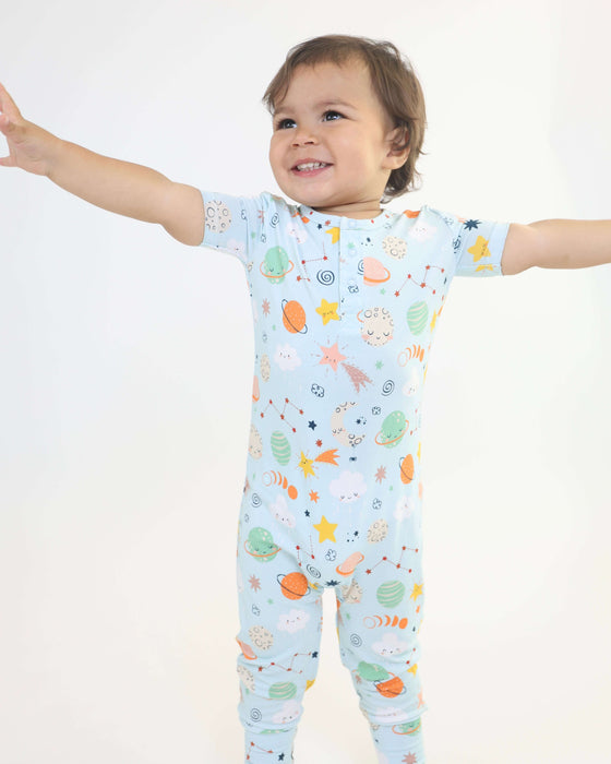 Child spreading open their arms while wearing a Rainn Bamboo Cosmic Pull Up Romper on a white background