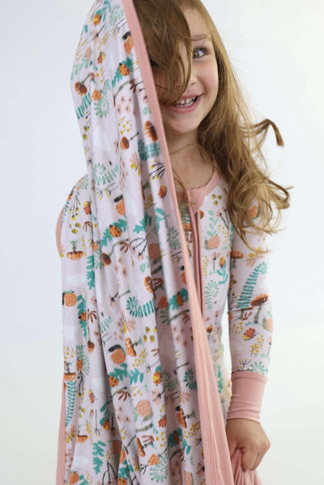 Child wearing a Rainn Bamboo Fern Blanket over their head on a white background