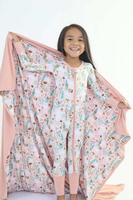 Child holding a Rainn Bamboo Fern Blanket on a white background