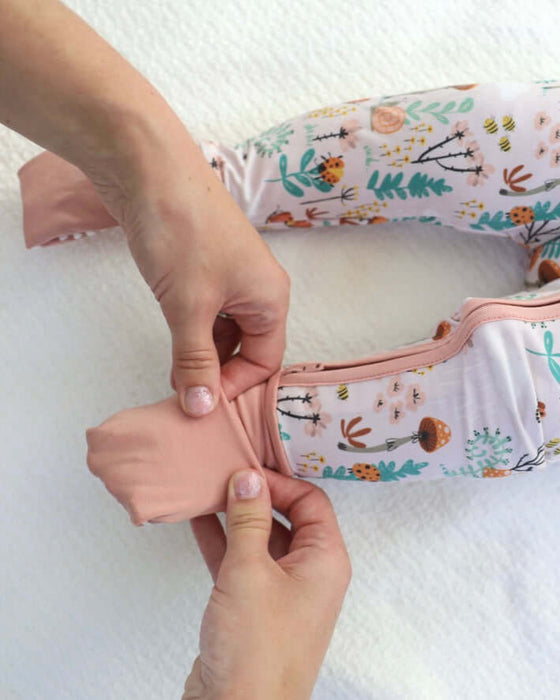 Detail of parent adjusting Rainn Bamboo Fern Zipp Jammies foot covers on a white background