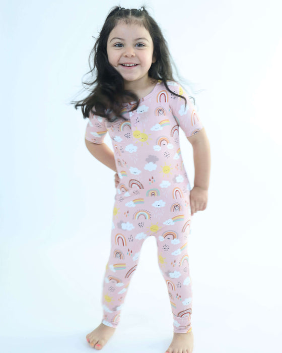 Child standing while wearing a Rainn Bamboo Rainnbow Pull Up Romper on a white background
