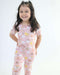 Child smiling while wearing a Rainn Bamboo Rainnbow Pull Up Romper on a white background