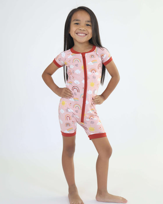Child standing and wearing a Rainn Bamboo Rainnbow Short Zipp Romper on a white background
