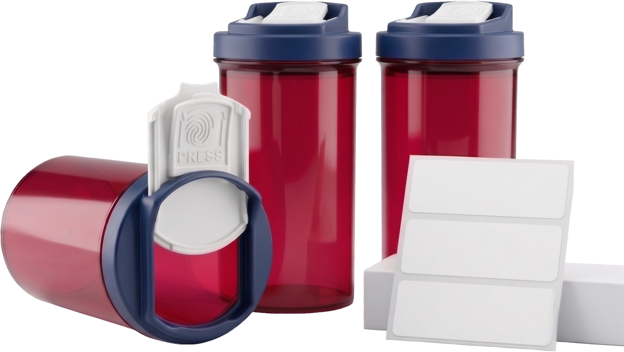 Three red translucent SnapSlide prescription vials with navy blue caps, one on its side with its white PRESS tab slid open, beside a sheet of three blank white labels on a white background